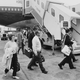 A black and white photo of passengers boarding the first BOAC 747 jumbo jet used for a commercial flight